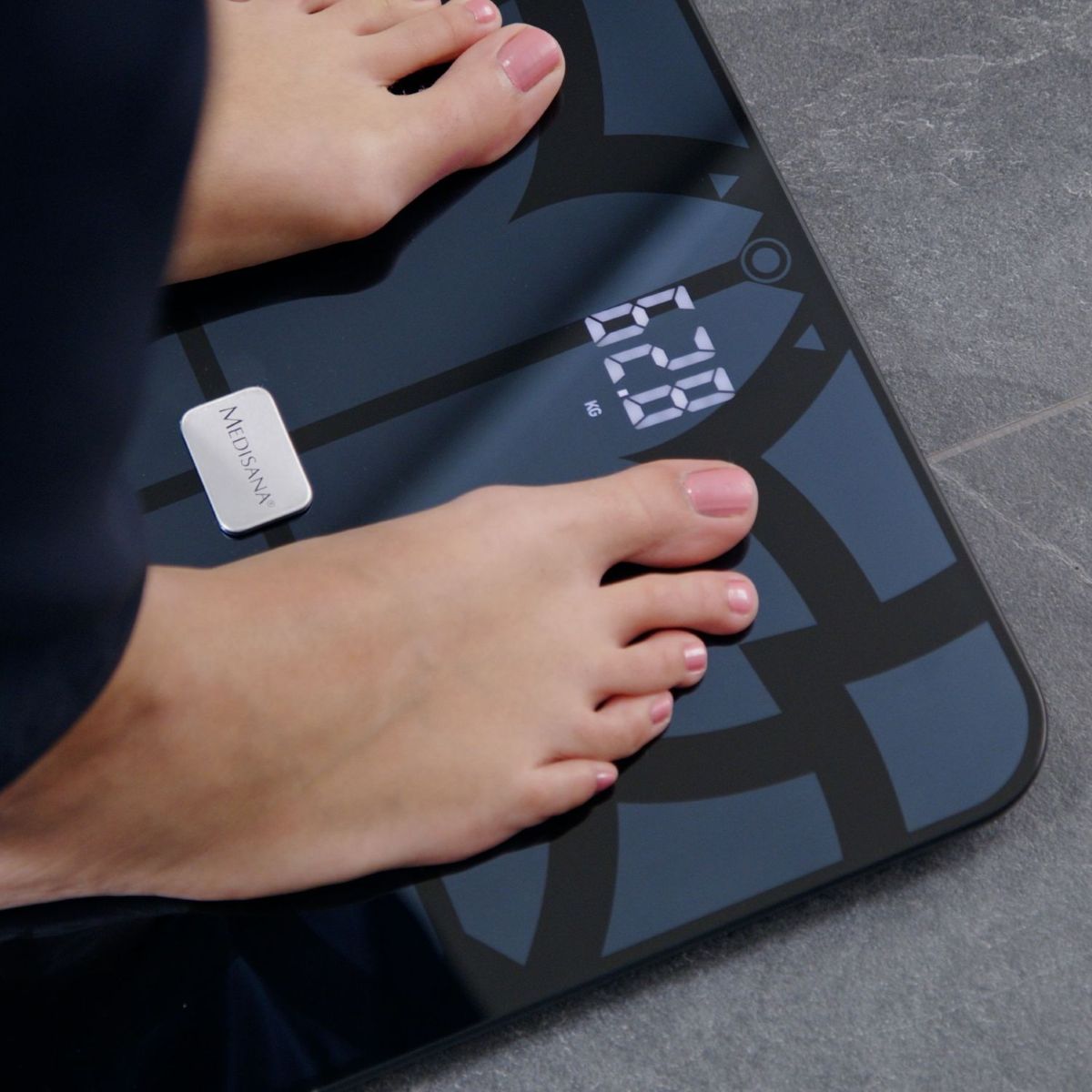 Nahaufnahme von Füßen auf einer digitalen Personenwaage, die ein Gewicht von 62,8 kg anzeigt.