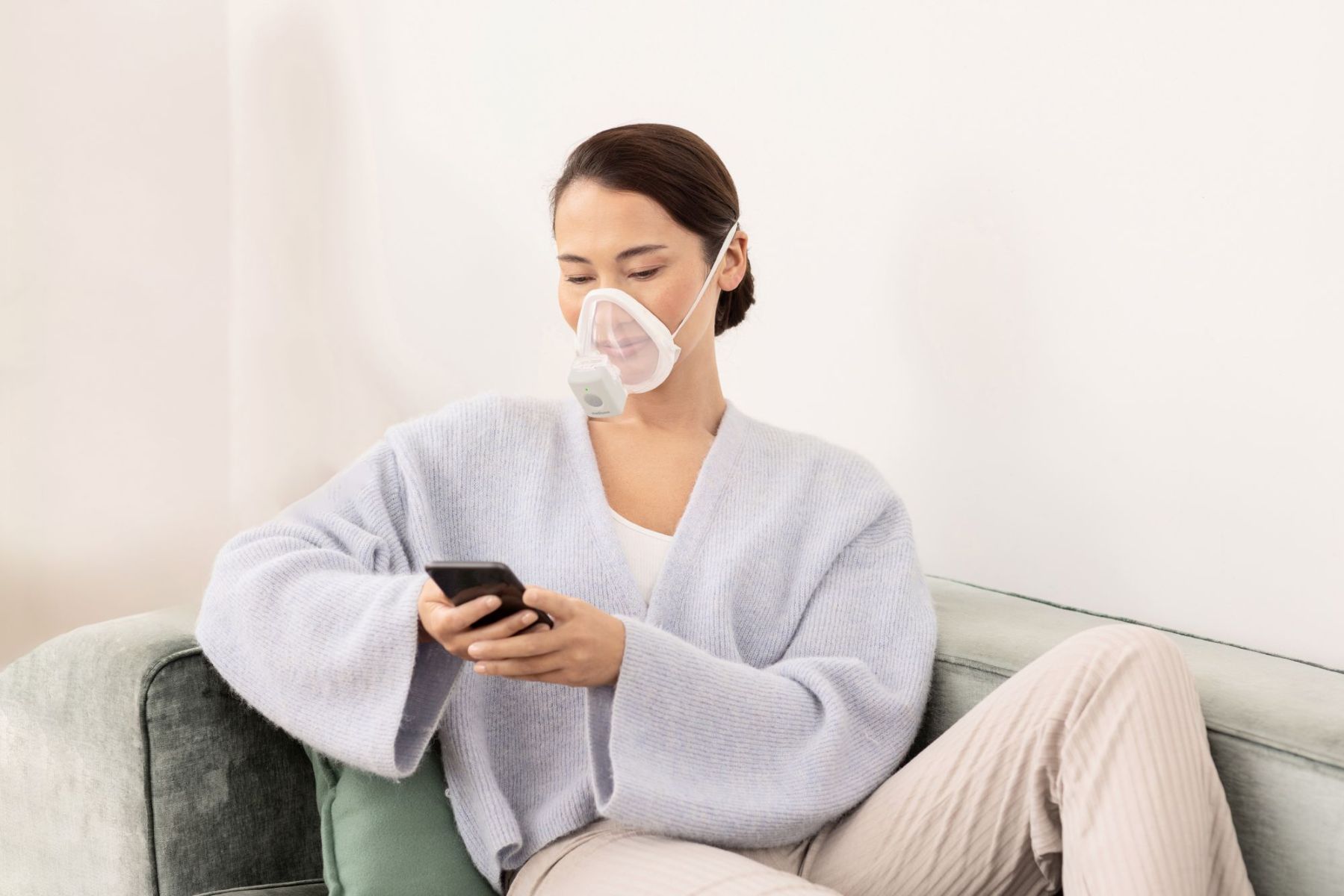 Frau nutzt den Medisana IN 705 Inhalator mit Maske bequem auf dem Sofa – wirksame Inhalationstherapie bei Atemwegserkrankungen